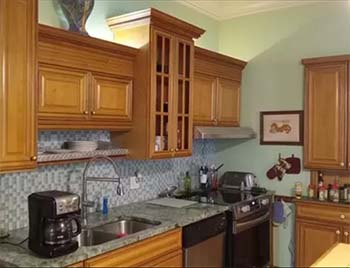 All-wood kitchen cabinets with raised panel doors and upper glass display cabinet