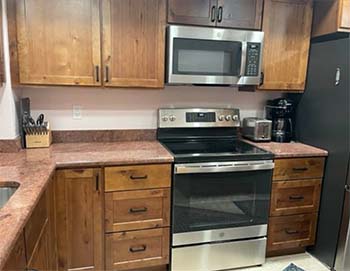 All-wood kitchen cabinets with flat panel doors and stainless steel appliances